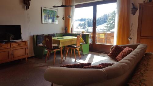 sala de estar con sofá y mesa en Ferienhaus Lucia, App.11 en Schönwald