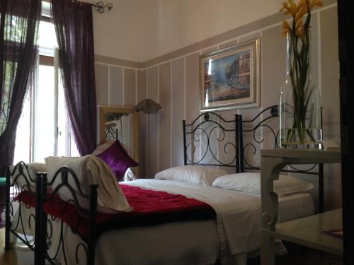 a bedroom with a black bed with a red blanket at Hotel Mignon in Trieste