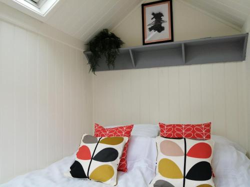 a bedroom with a bed with colorful pillows on it at Ty bech twt in Machynlleth
