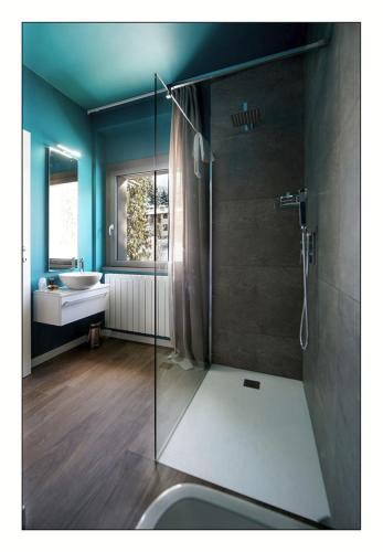a bathroom with a glass shower and a sink at Il Rifugio del Risol in Castione della Presolana
