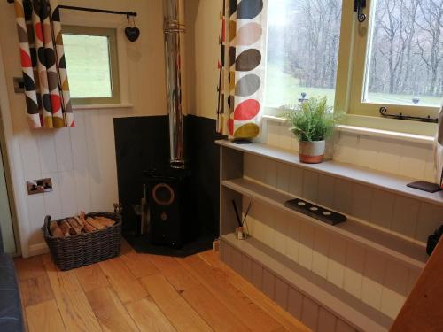 a living room with a wood stove and a window at Ty bech twt in Machynlleth