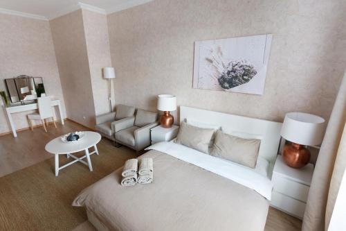 a bedroom with a large white bed and a couch at Tverskaya Street Apartments in Moscow