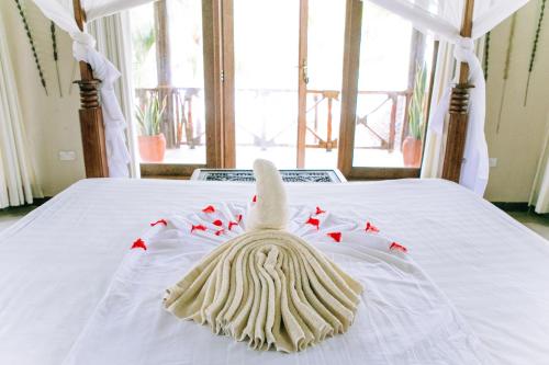 a white bed with a towel on top of it at Tamani Villas in Matemwe