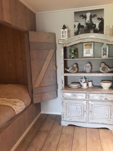 a bedroom with a wooden door and a dresser at De Bedstee in Holwerd