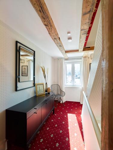 a living room with a dresser and a red carpet at WachtRaum Reutlingen - Altstadt Apartment & Design Rooms an Stadthalle & Marktplatz in Reutlingen