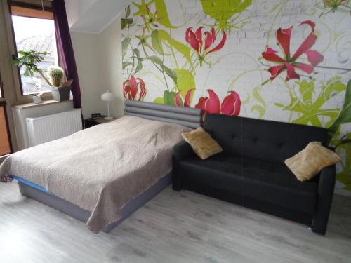 um quarto com uma cama e uma parede com flores em Apartament Happy em Świnoujście