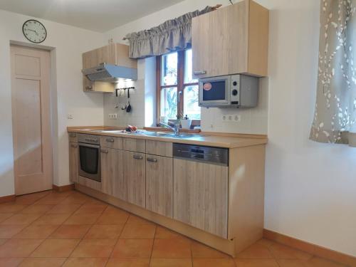 a kitchen with wooden cabinets and a sink and a window at Pension Ober in Siegsdorf