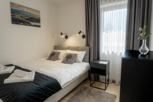 1 dormitorio con 1 cama con sábanas blancas y ventana en Apartament w Kluszkowcach nad Jeziorem Czorsztyńskim en Kluszkowce