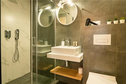 a bathroom with a shower and a sink and mirror at Apartament w Kluszkowcach nad Jeziorem Czorsztyńskim in Kluszkowce