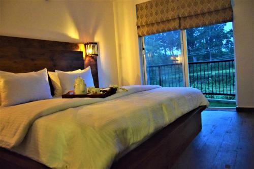 a bedroom with a large bed and a window at Lake Infinity Luxury Condos in Nuwara Eliya