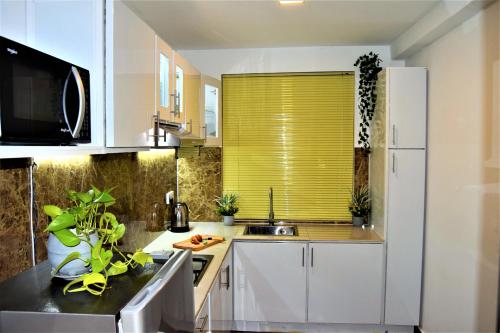 a kitchen with a yellow blind on a window at Lake Infinity Luxury Condos in Nuwara Eliya