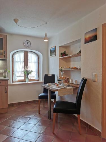 a kitchen with a table and chairs and a window at Pension Ober in Siegsdorf