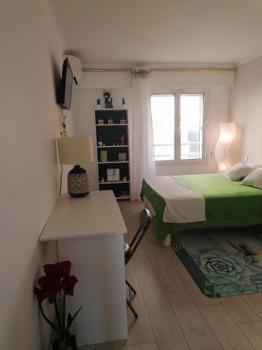 une chambre avec un lit, un bureau et une fenêtre dans l'établissement Appartement triangle d'or Saint Raphaël, à Saint-Raphaël