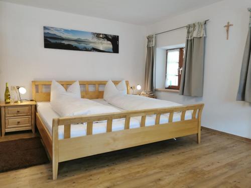 a bedroom with a large wooden bed with white pillows at Pension Ober in Siegsdorf