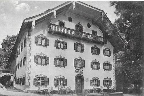 a black and white photo of a building with a balcony at Pension Ober in Siegsdorf