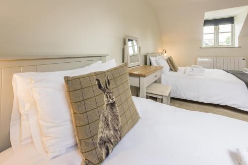 a hotel room with two beds and a desk at The Hopton Crown in Cleobury Mortimer
