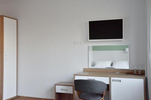 a room with a desk and a tv on the wall at Tip Tap Guest House in Druskininkai