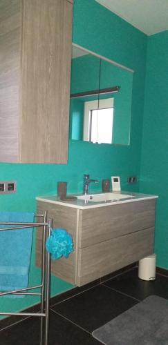 La salle de bains est pourvue d'un lavabo et d'un miroir. dans l'établissement chez Chantal - appartement privatif, à Yvoir