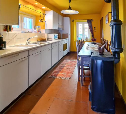 a kitchen with white cabinets and a blue island at casa Radegonda in Sornico