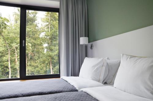 a bedroom with a bed and a large window at Tip Tap Guest House in Druskininkai