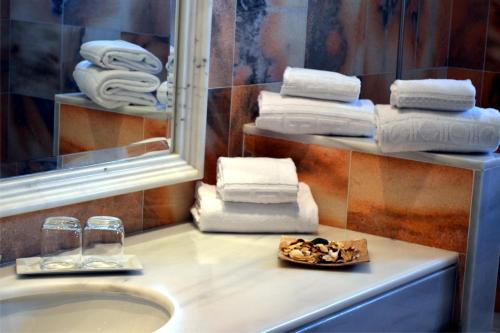 a bathroom with a sink and a mirror and towels at Villas Coral Deluxe in Playa Blanca