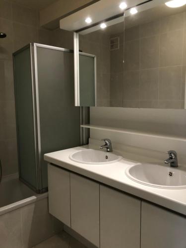 une salle de bain avec deux lavabos et un miroir dans l'établissement Westende Zeezicht, à Middelkerke
