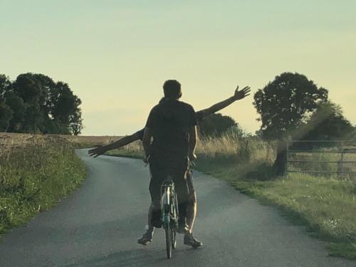a man riding a bike down a road with his arms out at La Source in Breuil