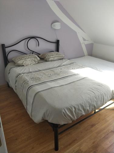a bed with a black frame and two pillows on it at Au bon acceuil in Channay-sur-Lathan