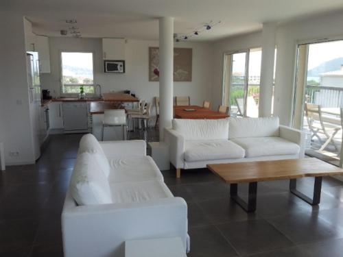 un salon avec des canapés blancs et une table dans l'établissement Appartement Terrasse dernier étage LES TERRASSES DE VIGNOLA, à Porto-Vecchio