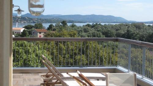 d'un balcon avec des chaises et une vue sur l'eau. dans l'établissement Appartement Terrasse dernier étage LES TERRASSES DE VIGNOLA, à Porto-Vecchio
