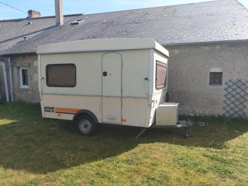 une remorque blanche garée devant une maison dans l'établissement Au bon acceuil, à Channay-sur-Lathan