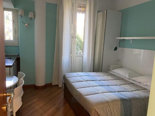 1 dormitorio con cama, mesa y ventana en Luna Rossa Roma Guest House, en Roma