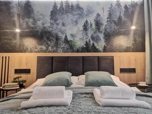 a bedroom with a large bed with two pillows on it at Apartament Liliowa Przełęcz in Zakopane