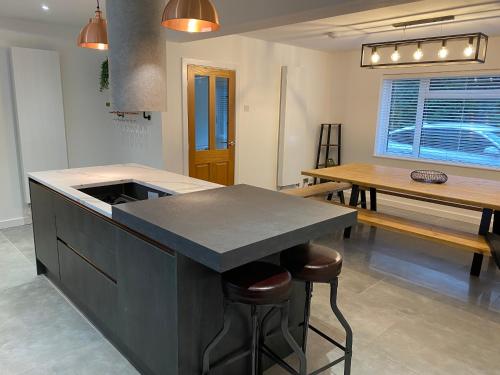 eine Küche mit einer Theke und ein Esszimmer mit einem Tisch in der Unterkunft Rhos Walia,near Snowdonia,Hot tub in Caernarfon