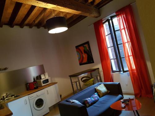 a living room with a blue couch and a window at Appartement Roquette Serenity in Arles