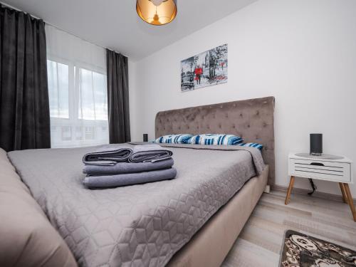 ein Schlafzimmer mit einem Bett mit Handtüchern darauf in der Unterkunft Avantgarden King Apart in Braşov