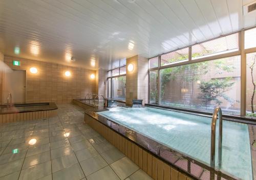 a large swimming pool in a building with a large window at Nagoya B's Hotel in Nagoya
