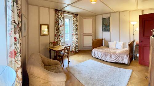 a bedroom with a bed and a couch and a table at l'Attique du Château in Cormondreche