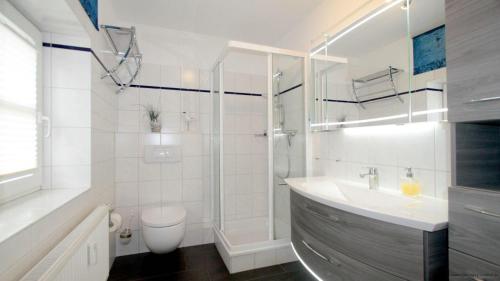 y baño con ducha, lavabo y aseo. en Gaestehaeuser-Heidehof-Wohnung-1 en Süderhöft