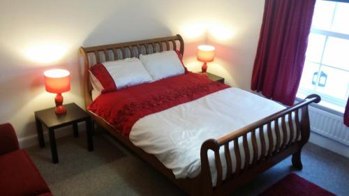 a bedroom with a large bed with two lamps at Riverbank Guest House in Wiggenhall Saint Germans