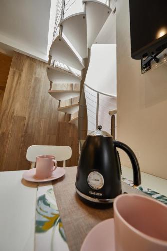 a black tea kettle sitting on a counter next to a spiral staircase at Liconti Exclusive Rooms in Pulsano