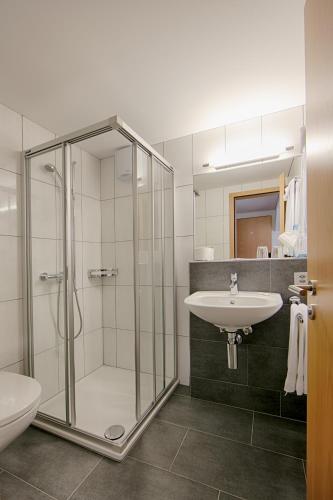 a bathroom with a shower and a sink at Loosmühle in Weissbad