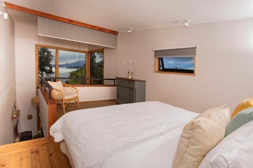 una camera con letto bianco e balcone di Cala Melí a Puerto Varas