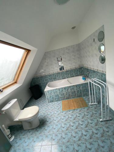 La salle de bains est pourvue d'une baignoire, de toilettes et d'un lavabo. dans l'établissement Maison à 20 mètre de la plage vue sur Mer, à Esquibien