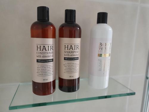 three bottles of hair consultation with change on a shelf at Lodge Lagom - Luxury guesthouse in Hammarstrand