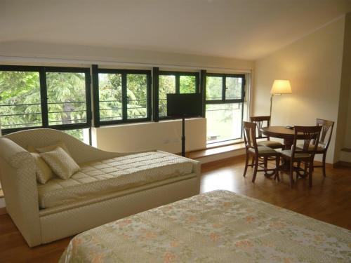 - une chambre avec un canapé, une table et des chaises dans l'établissement Relais Villa Selle, à Fumane
