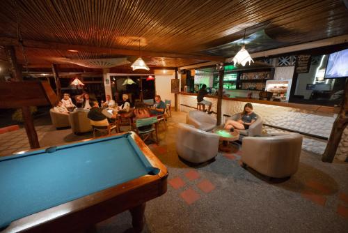 una mesa de billar en un bar con gente sentada en sillas en Hotel Las Ninfas, en Puerto Ayora