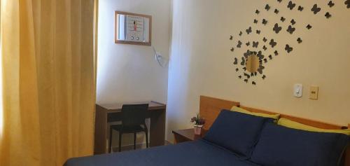 a bedroom with a bed and a table with a desk at Prive das Thermas - 301B in Caldas Novas