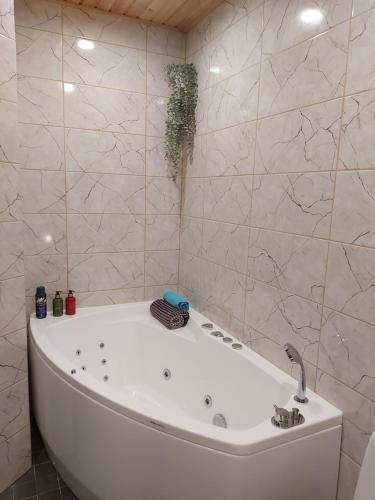 y baño con bañera blanca y azulejos de mármol. en Aare Accommodation, en Valga