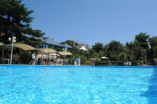 a large swimming pool with blue water at Hotel Villa Rosa in Martina Franca